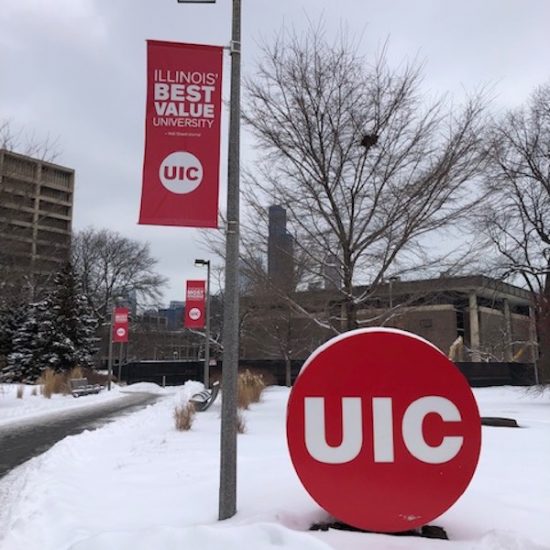 white snow on UIC lawn with bright red UIC banners and sign on display