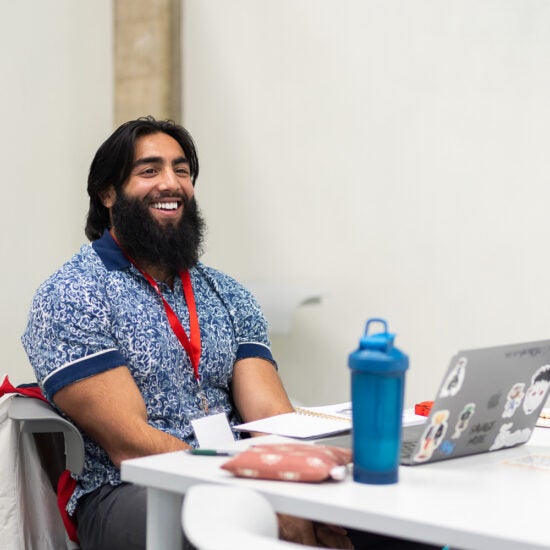 Student worker sitting at a desk with a laptop in front of him