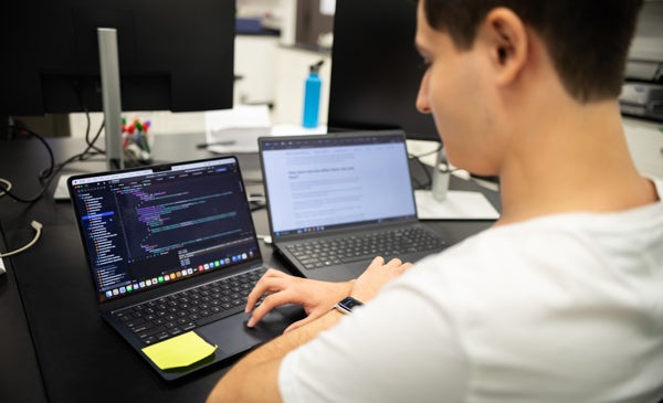 Student writing out mathmatical equations on laptop